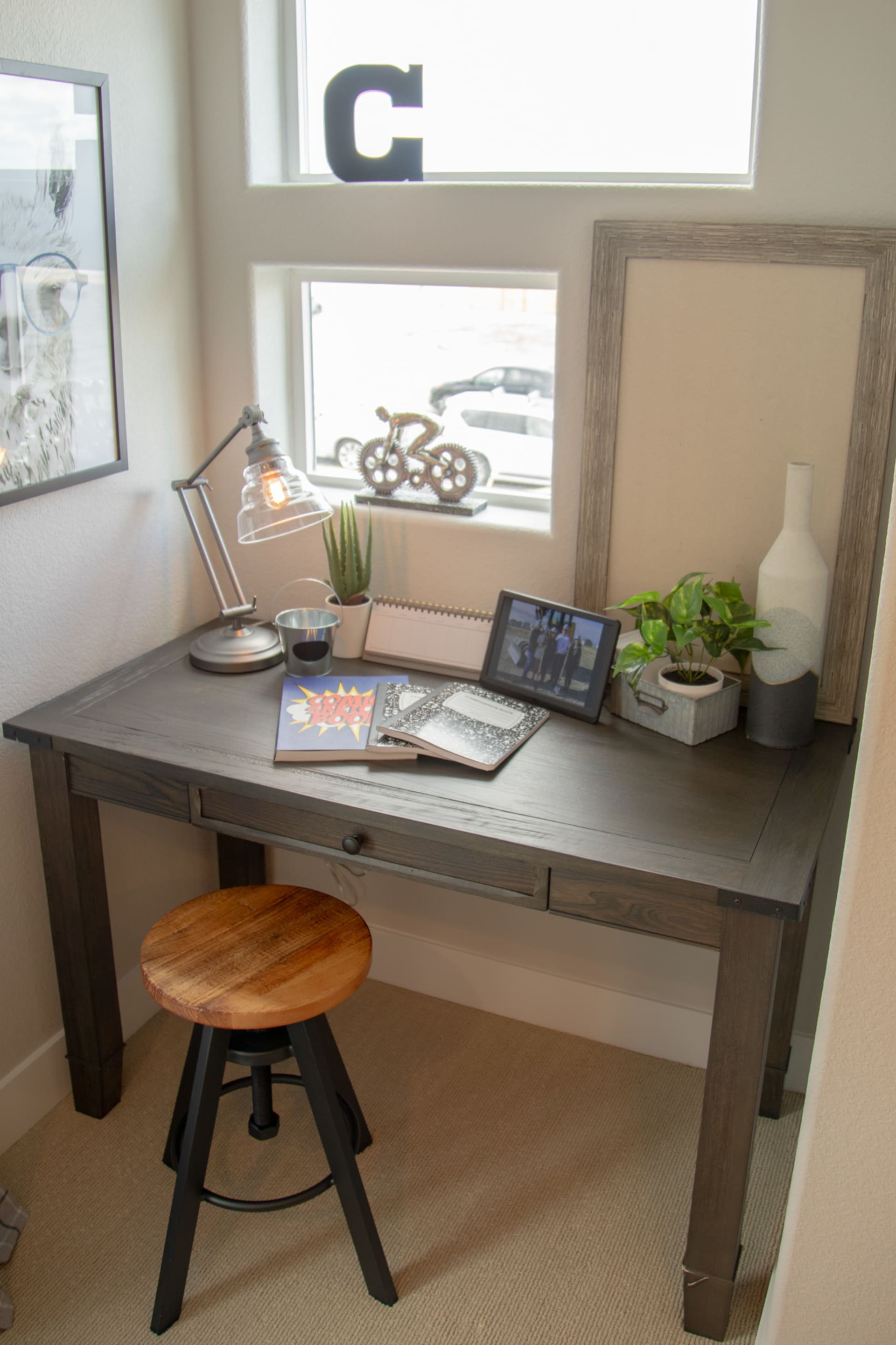 A window scene featuring the gray wood Whiskey River Pocket Desk tucked into small nook